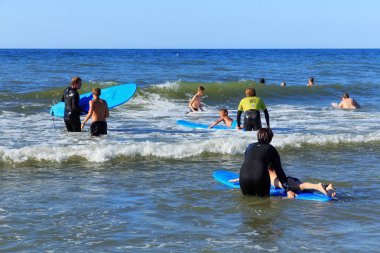 Zelenogradsk, Kaliningrad bölgesi, Rusya Federasyonu - 29 Temmuz 2017: dinlenme ve yaz saati, Baltık Denizi'nin mavi dalgalar üzerinde profesyonel eğitmenler ile sörf öğrenme bilinmeyen çocuk.