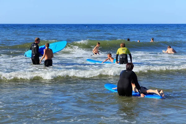 Zelenogradsk, Kaliningrad bölgesi, Rusya Federasyonu - 29 Temmuz 2017: dinlenme ve yaz saati, Baltık Denizi'nin mavi dalgalar üzerinde profesyonel eğitmenler ile sörf öğrenme bilinmeyen çocuk.