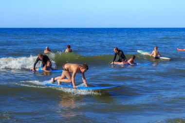 Zelenogradsk, Kaliningrad bölgesi, Rusya Federasyonu - 29 Temmuz 2017: dinlenme ve yaz saati, Baltık Denizi'nin mavi dalgalar üzerinde profesyonel eğitmenler ile sörf öğrenme bilinmeyen çocuk.