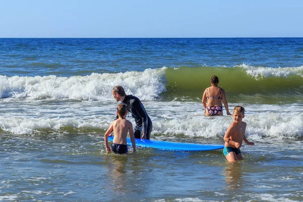 Zelenogradsk, Kaliningrad bölgesi, Rusya Federasyonu - 29 Temmuz 2017: dinlenme ve yaz saati, Baltık Denizi'nin mavi dalgalar üzerinde profesyonel eğitmenler ile sörf öğrenme bilinmeyen çocuk.