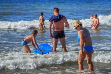 Zelenogradsk, Kaliningrad bölgesi, Rusya Federasyonu - 29 Temmuz 2017: Bilinmeyen çocuk dinlenme ve yaz saati, Baltık Denizi'nin mavi dalgalar üzerinde sörf öğrenme surfboard ile.