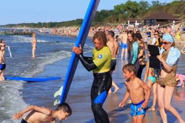 Zelenogradsk, Kaliningrad bölgesi, Rusya Federasyonu - 29 Temmuz 2017: Bilinmeyen sörfçü ile ünlü tatil Zelenogradsk yaz saati, Baltık Denizi kıyısında kumlu bir plaj üzerinde sörf tahtası duran.