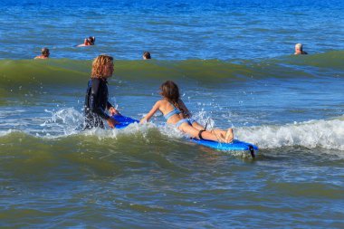 Zelenogradsk, Kaliningrad bölgesi, Rusya Federasyonu - 29 Temmuz 2017: dinlenme ve yaz saati, Baltık Denizi'nin mavi dalgalar üzerinde profesyonel eğitmenler ile sörf öğrenme bilinmeyen çocuk.