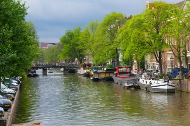 Amsterdam, Hollanda - 25 Haziran 2017: Eski binalar yakınındaki Amsterdam tarihi kısmında su kanallarının biri.