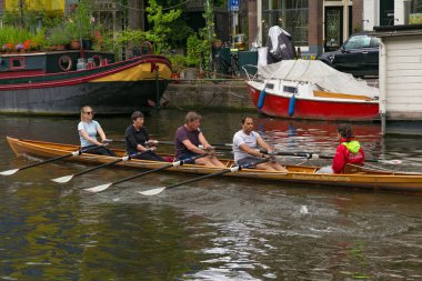 Amsterdam, Hollanda - 25 Haziran 2017: Amsterdam'da merkezi su kanallarının biri üzerinde kürek in Eğitim.