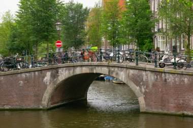Amsterdam, Hollanda - 25 Haziran 2017: Eski tuğla köprü üstünde su kanallarının Amsterdam tarihi kısmında bir.