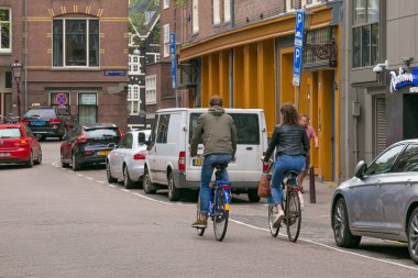 Amsterdam, Hollanda - 25 Haziran 2017: Bilinmeyen bisikletçiler Amsterdam Merkez caddeleri üzerinde.