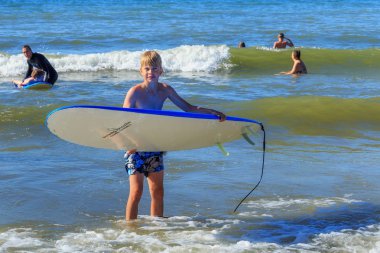 Zelenogradsk, Kaliningrad bölgesi, Rusya Federasyonu - 29 Temmuz 2017: Bilinmeyen çocuk dinlenme ve yaz saati, Baltık Denizi'nin mavi dalgalar üzerinde sörf öğrenme surfboard ile.