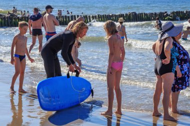 Zelenogradsk, Kaliningrad bölgesi, Rusya Federasyonu - 29 Temmuz 2017: Bilinmeyen genç kız Baltık Denizi Plajı'nda sörf hocası yanında duruyor.