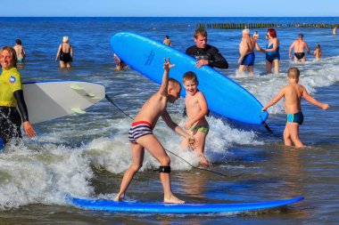 Zelenogradsk, Kaliningrad bölgesi, Rusya Federasyonu - 29 Temmuz 2017: dinlenme ve yaz saati, Baltık Denizi'nin mavi dalgalar üzerinde profesyonel eğitmenler ile sörf öğrenme çocuk.