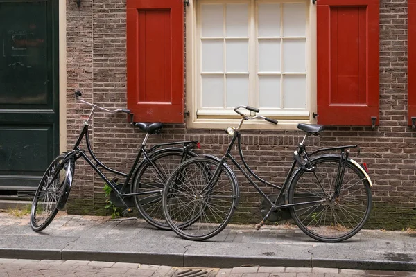 Dos Bicicletas Negras Antiguas Cerca Pared Ladrillo Rojo Centro Ámsterdam — Foto de Stock