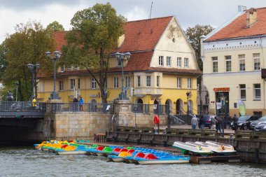 Klaipeda, Litvanya - 22 Eylül 2018: Park arka plan üzerinde eski tarihi bina ile su bisiklet (eski şehir Memel adıdır) Klaipeda tarihi kesiminde Dane Nehri üzerinde.