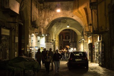 NAPLES, ITALY - 31 Ekim 2015: Napoli 'nin tarihi bölümündeki eski püskü sokaklardan birinde bilinmeyen insanlar.