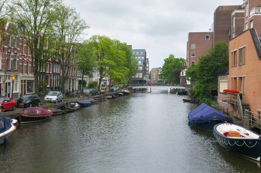 Amsterdam, Hollanda - 25 Haziran 2017: Amsterdam tarihi kısmında su kanallarının biri üzerinde farklı tekneler.
