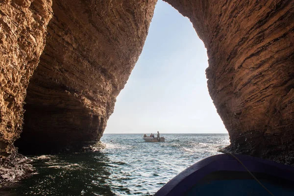 Lancha a motor en el mar Mediterráneo con turistas desconocidos bajo el arco de la famosa Paloma Rocas en el distrito de Raouche en Beirut . — Foto de Stock