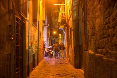 Gece Napoli tarihi kesiminde eski pejmürde dar caddelerden birinde bilinmeyen insanlar.