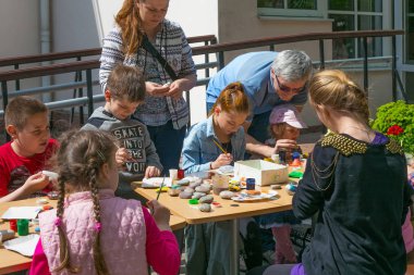 Kaliningrad bir sokak atölyesinde taşlar üzerinde çizim okuyan bilinmeyen çocuklar.