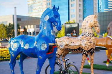 Nurzhol Bulvarı 'nda Astana 'da farklı etnik süslemede boyalı atların figürleri ile sanat montajı