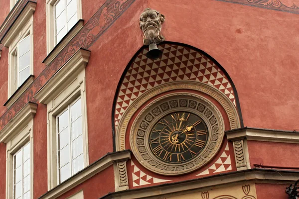 Gran reloj antiguo como parte de las decoraciones en la esquina de una de las casas históricas en el casco antiguo de Varsovia . — Foto de Stock