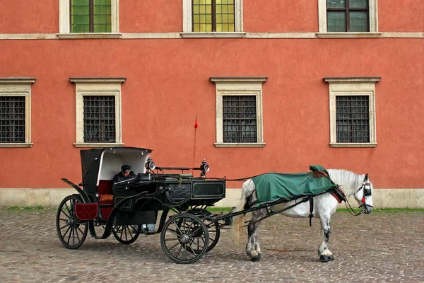 Chariot touristique en face du mur rouge du château royal dans la partie historique de Varsovie . — Photo
