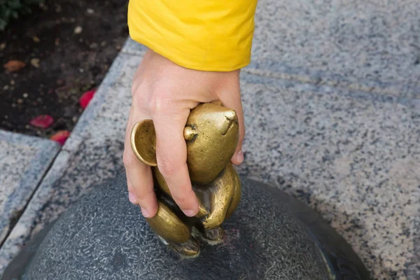 Escultura conocida como Wonderful Little Mouse y mano humana. Es pequeña estatua una de las esculturas más famosas de la ciudad de Klaipeda . — Foto de Stock