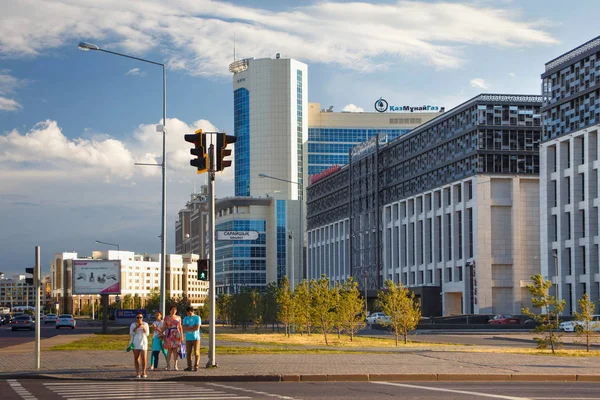 Personas desconocidas en un cruce peatonal en el centro de Astana con edificios modernos en el fondo . — Foto de Stock