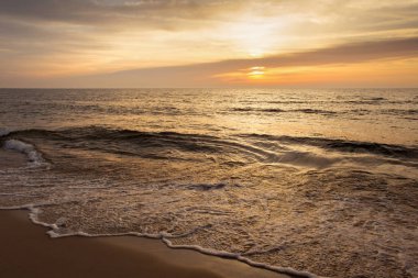 Güzel gün batımı deniz manzarası güneş ve küçük dalgalar ile.