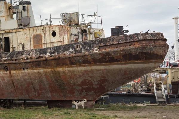 Rusty decommissioned marine ship that was left on the shore.