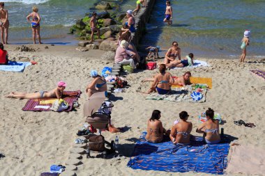 Bilinmeyen insanlar yaz aylarında ünlü tatil Zelenogradsk (eski Cranz olarak da bilinir) Baltık Denizi kıyısında kum plajda güneşleniyor.