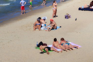 Bilinmeyen insanlar yaz aylarında ünlü tatil Zelenogradsk (eski Cranz olarak da bilinir) Baltık Denizi kıyısında kum plajda güneşleniyor.