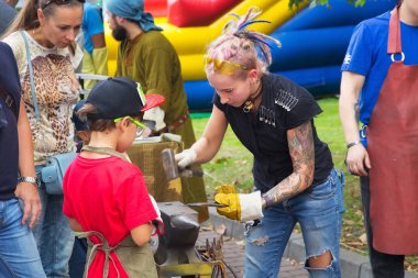 Zelenogradsk dövme Demircilik ve sanat sokak açık atölye bir çırak demirci olarak bilinmeyen çekici kız.