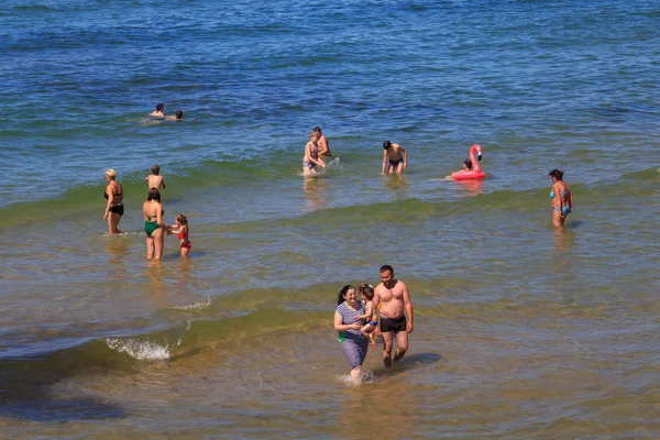 Неизвестные купаются в голубой воде Балтийского моря на знаменитом курорте Зеленоградск (ранее известном как Кранц) летом . — стоковое фото