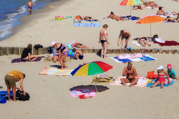 여름에 유명한 리조트 젤레노그라드스크 (이전 크란츠로 알려진)에서 발트 해 해안의 모래 해변에서 일광욕을하는 알 수없는 사람들. — 스톡 사진
