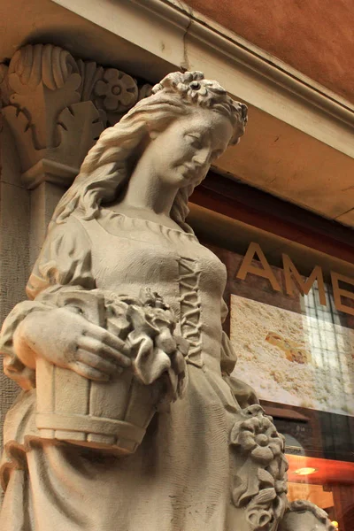 Escultura antigua de mujer joven cerca de la ventana de la tienda de recuerdos Ámbar en el centro histórico de Varsovia . — Foto de Stock