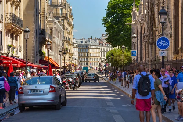Touristen spazieren auf der historischen Straße rue du cloitre-notre-dame neben der berühmten Kirche Notre-dame-de-paris. — Stockfoto