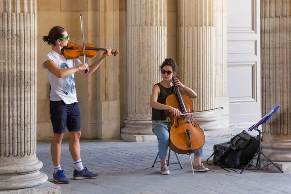 Unknown street musicians playing on the territory of the famous Louvre Palace in summer day. — Stock Photo, Image