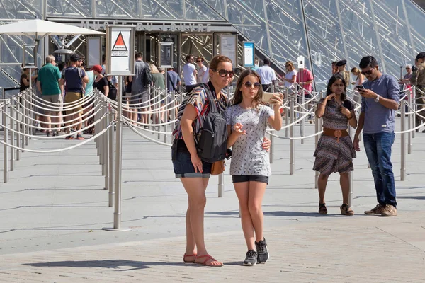 Άγνωστοι τουρίστες παίρνουν μια selfie κοντά στη διάσημη γυάλινη πυραμίδα του Μουσείου του Λούβρου — Φωτογραφία Αρχείου