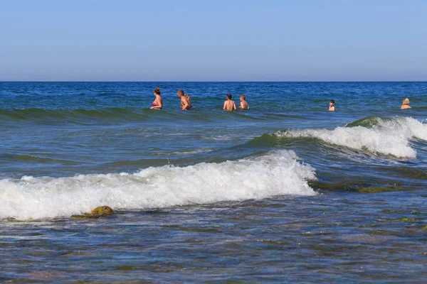 Unknown people bathing in blue water of the Baltic Sea in famous resort Zelenogradsk (formerly known as Cranz) at summer. Royalty Free Stock Photos