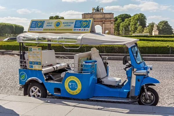 Pohled na turistickou motorovou tříkolku na silnici nedaleko vítězné klenby du Carrousel a slavného paláce Louvre (na druhé straně) v letním dni. — Stock fotografie