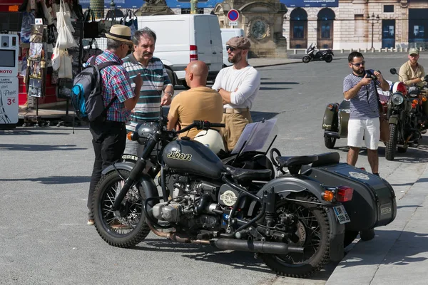 Neznámí lidé hovoří v centru Paříže poblíž velkého černého motocyklu s postranním vozíkem. — Stock fotografie