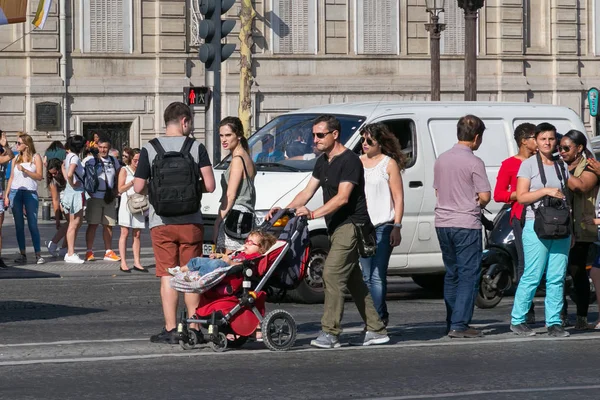 Neznámý muž s dětskou kočárem na kříži v centru Paříže na Avenue des Champs-Elypse. — Stock fotografie