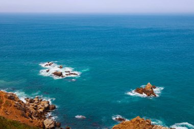 Güneşli bir günde Fas 'taki Atlantik Okyanusu kıyısındaki taş adaların manzarası..
