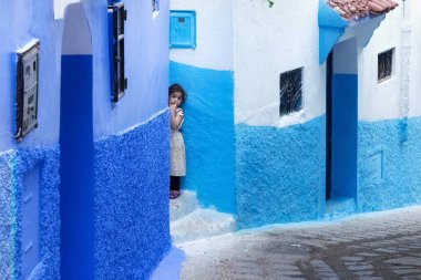 CHEFCHAOUEN, FOCCO - 28 Mayıs 2017: Medine, Chaouen 'de bilinmeyen genç kız. Şehir binalarının mavi tonlarıyla ünlüdür ve bu Şef 'i ziyaretçiler için çok çekici kılar..