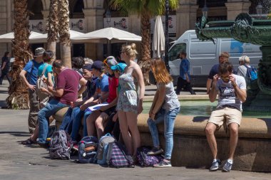 BARCELONA, SPAIN - 15 Mayıs 2017: Placa Reial 'deki (İngilizce Kraliyet Meydanı, İspanyolca Plaza Real) eski çeşmenin yanında dinlenen bilinmeyen insanlar). 
