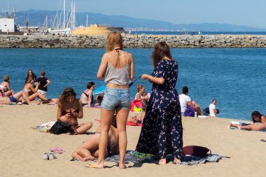 BARCELONA, İspanya - 15 Mayıs 2017: Bilinmeyen kadınlar Barcelona 'da bir şehir plajında güneşleniyor ve dinleniyorlar.