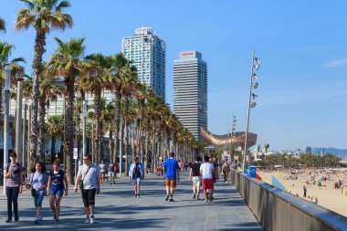 BARCELONA, SPAIN - 15 Mayıs 2017: Akdeniz kıyısındaki Barcelona şehir plajının yakınındaki gezinti alanında bilinmeyen insanlar. Modern gökyüzü manzarası ve mavi gökyüzü.