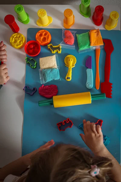 Yaratıcı eğlence için oyun aletleri ve hayvan kesicileri düzenleyen çocukların elleri.