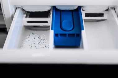 Detergent compartment filled with powder in washing machine drawer