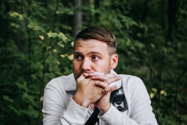 A thoughtful look of a man sitting in the forest