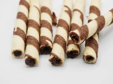 Kremayla doldurulmuş, kakao şeritleriyle süslenmiş, beyaz üzerine izole edilmiş gevrek gofret çubukları.